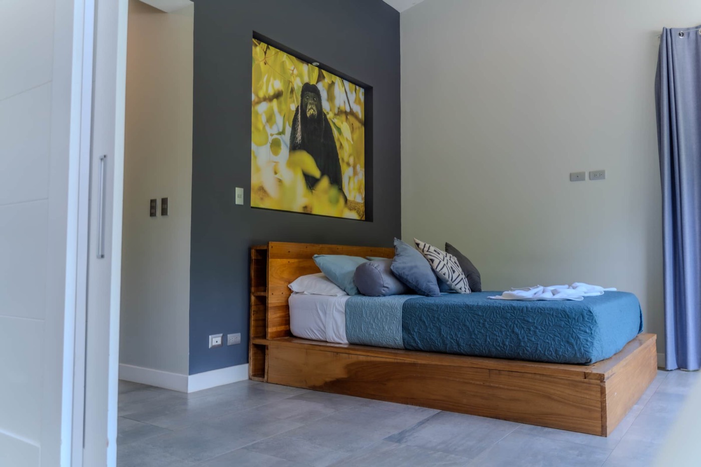 Chambre avec lit queen et tableau du singe hurleur